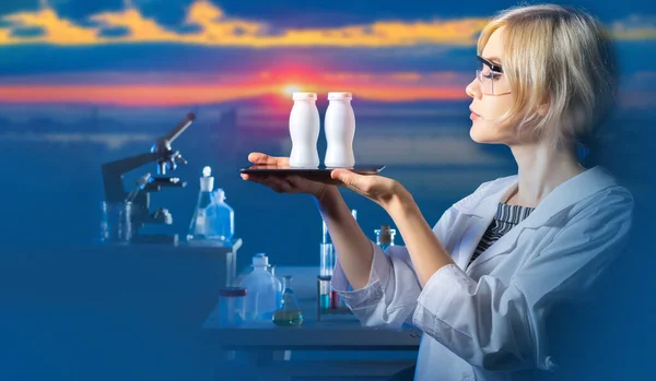 Biologically active additives. Female laboratory assistant holds white bottle. Biologist demonstrates finished product. Microbiologist at sunset. Concept - developed biologically active additives.