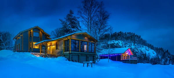 Cottages in the background of a mountain. Houses in the wild. Country houses in the winter landscape.