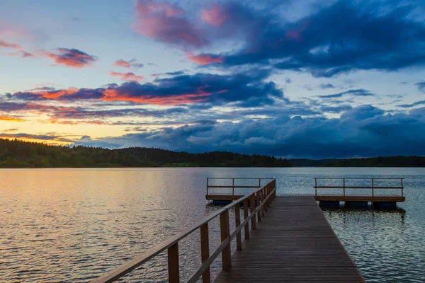 Wooden pier. Clouds over the lake. Lake. Sunset of the day.