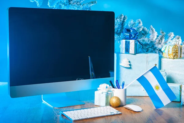 Gifts for Christmas. Gifts on the table. Place for congratulations on Christmas. New Year. New Year\'s greetings. Computer monitor for the inscription. Christmas in Argentina. Flag of Argentina.