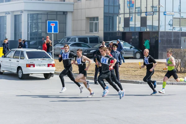 Surgut, Russia - MAY 9, 2018: Young athletes guys run baton through streets of the city. Holiday Victory Day May 9th. — Stock Photo, Image