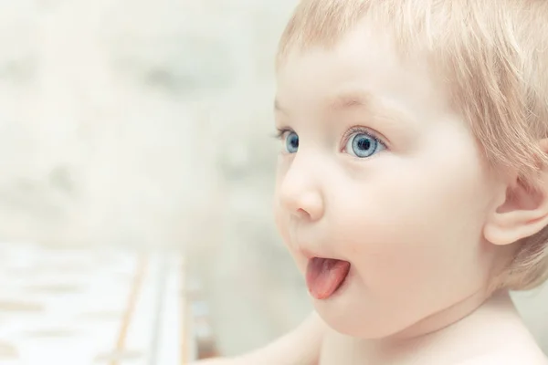 Симпатична дитина з блакитними очима застрягла язиком в очікуванні їжі . — стокове фото