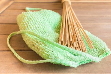 Bambu süpürge ile yeşil sünger banyoda rafta yalan