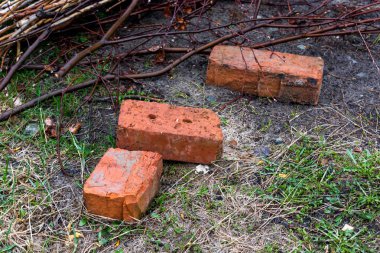 Yerde yatan üç kırmızı tuğla.