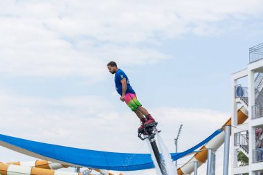 Side, Türkiye - 1 Haziran 2018: Yakışıklı tabaklanmış adam sineklikte duruyor ve bulutlarla mavi gökyüzüne uçuyor.
