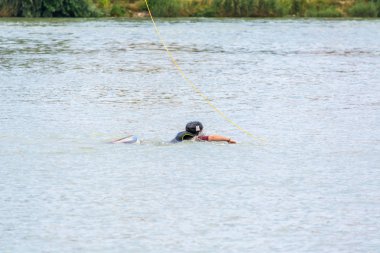 Krasnodar, Rusya - 7 Haziran 2018: Kasklı atletik adam su tutma ipinin üzerine biniyor.