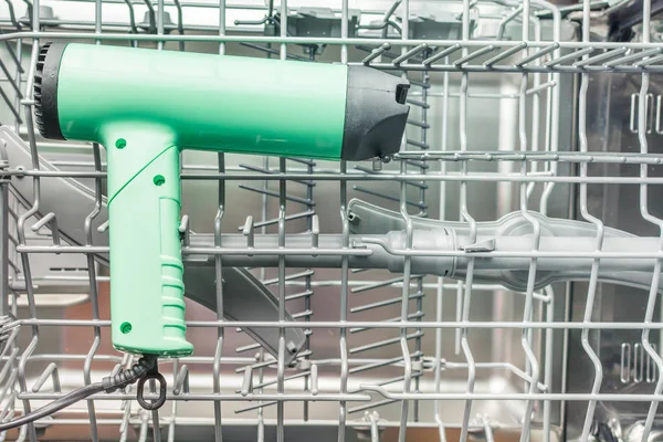 Green hairdryer is in the dishwasher — Stock Photo, Image