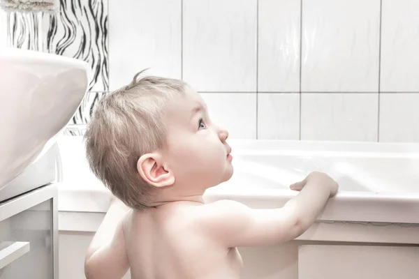 Happy baby girl preparing to bathe in the tub — Stock Photo, Image