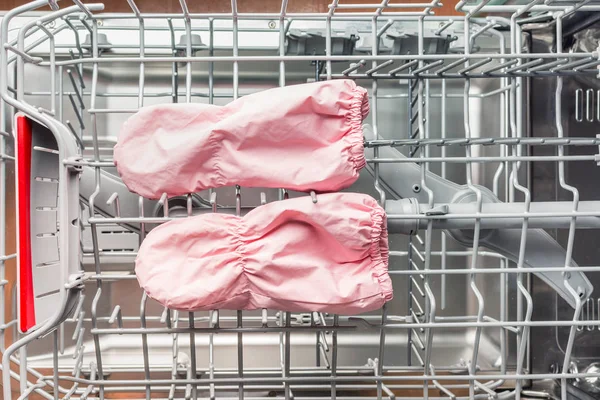 Пара детских варежок лежит в посудомоечной машине для стирки — стоковое фото