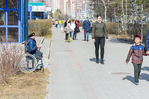 Surgut, Rusya - 9 Mayıs 2018: Arabada bere savurarak askeri engelli kişi yoldan geçenlerden para istiyor. Tatil Zafer Bayramı 9 Mayıs.