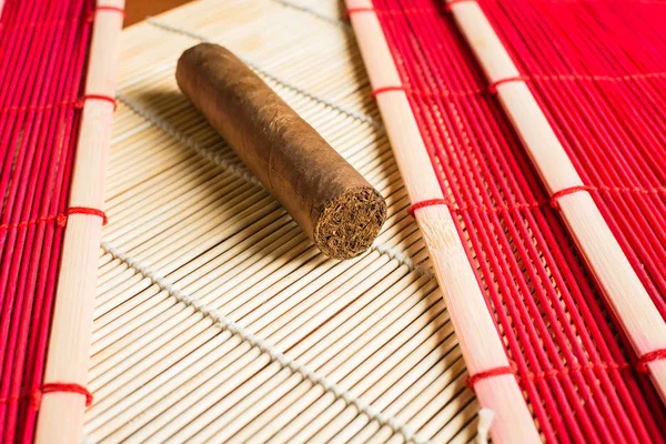 Большая сигара на бамбуковом коврике . — стоковое фото