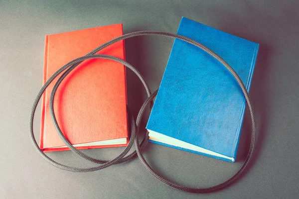 Livros coloridos envoltos em fio preto — Fotografia de Stock