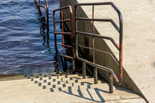 close up of iron stairs in water