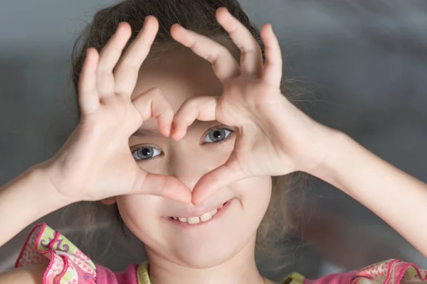 The beautiful eyes of the child in the hand heart — Stock Photo, Image