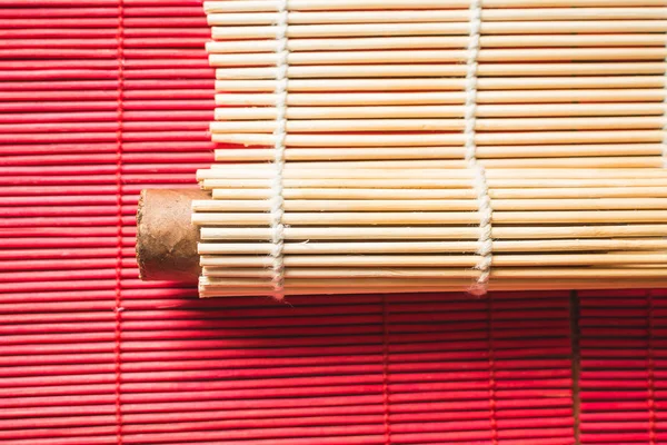 Charuto marrom envolto em tapete de bambu oriental . — Fotografia de Stock