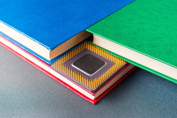 Processador de um computador com livros multicoloridos — Fotografia de Stock