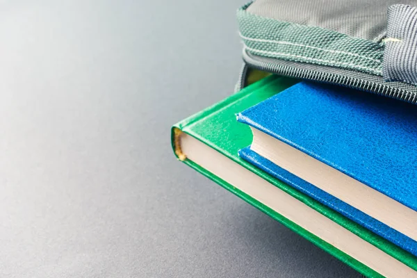 Зеленые и синие книги лежат в сумке для ноутбука — стоковое фото