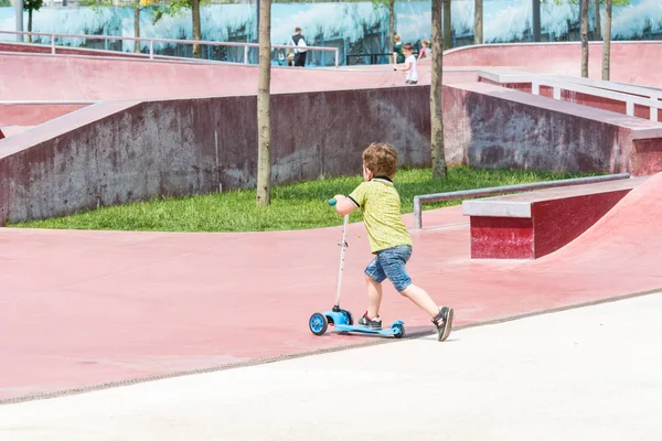 KRASNODAR, RUSSIA - 7 GIUGNO 2018: Piccolo bambino cavalca scooter per bambini su un campo sportivo speciale . — Foto Stock