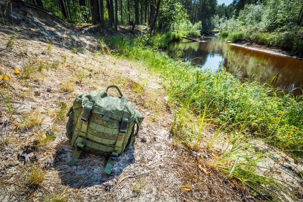 Kleine Marcherende Groene Rugzak Ligt Een Droge Bank Langs Rivier — Stockfoto