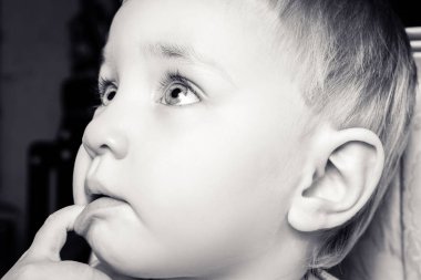 Güzel çocuk ağzına parmaklarını ısırır