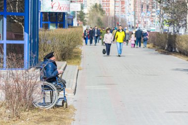 Surgut, Rusya - 9 Mayıs 2018: Arabada bere savurarak askeri engelli kişi yoldan geçenlerden para istiyor. Tatil Zafer Bayramı 9 Mayıs.