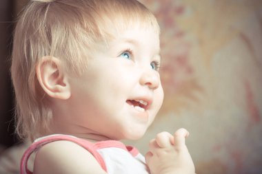 Güzel gülümseme ile neşeli çocuk mutlu ve yukarı bakar.