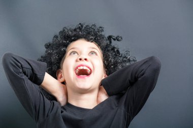 Siyah kıvırcık peruk mutlu kız bakar