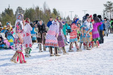 Russkinskaya, Rusya - 24 Mart 2018: Meydanda ulusal kuzey giyimli Sibiryalı kadınlar kızlar arasında bir yarış yarışmasına hazırlanıyor. Reindeer çobanları günü bayramı.