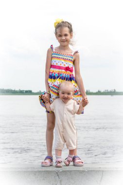 Nehirde iskelede yürüyen iki güzel kız kardeş