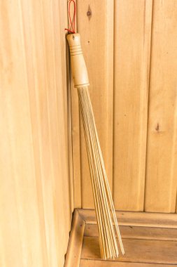 Bambu süpürge sauna köşesinde bir rafta duruyor