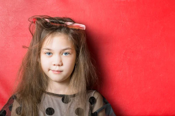 赤い櫛は赤い背景に美しい女の子の髪にハングアップ — ストック写真