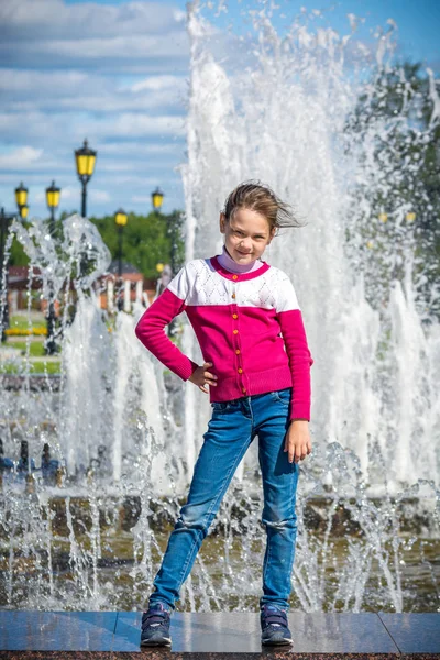 Enfant heureux posant à la fontaine dans le parc — Photo