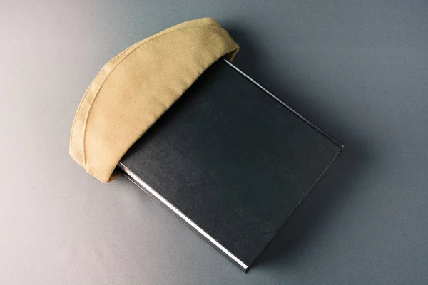 Yeşil askeri kap kara kitapta — Stok fotoğraf