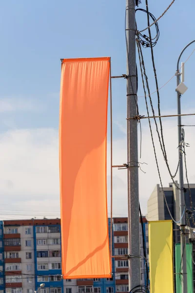 The orange flag hanging on a pole.