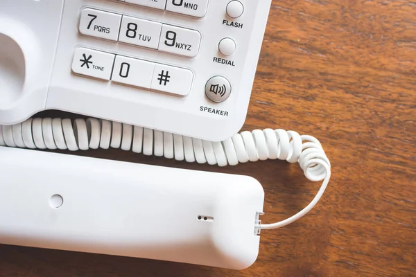 Telefone de escritório com o telefone apanhado na mesa de madeira . — Fotografia de Stock