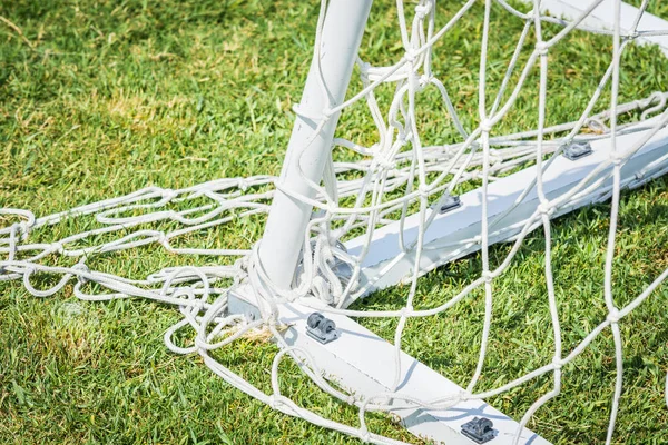 Narożnik białego gola w piłce nożnej z siatką na zielonej trawie. — Zdjęcie stockowe