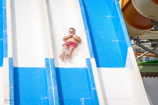 Lado, Turquía - Junio 2018: Un joven está rodando por un tobogán de agua en un parque acuático . — Foto de Stock