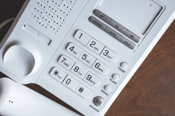 Telefone velho em botões e fora do gancho na mesa de madeira . — Fotografia de Stock