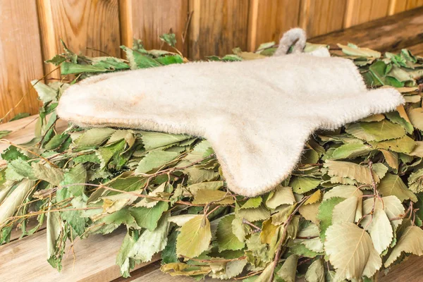 A mitene branca está em uma vassoura de vidoeiro em um banho — Fotografia de Stock