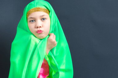 Oryantal dans için yeşil bir başörtüsü sarılmış güzel kız bir öpücük gönderir