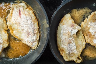 Tilapia balık fileto un ve ekmek kırıntıları tavada kızartmak için haddelenmiş.