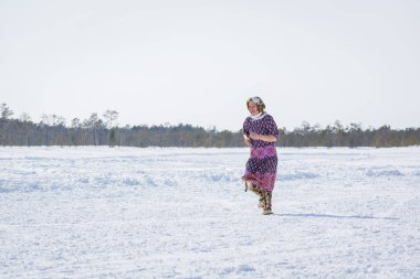 Russkinskaya, Rusya - 24 Mart 2018: Ulusal kuzey giyim yaşlı kadın kışın çapraz çalışır, diğerleri gerisinde. Kızlar arasındaki rekabet. Reindeer çobanları günü bayramı.
