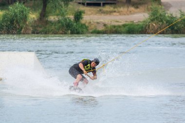Krasnodar, Rusya - 7 Haziran 2018: Kasklı spor adamı tahtadaki sıçrama tahtasından tross'a tutunarak atladı.