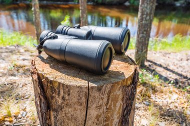 Ormanda kütük üzerinde kapalı lensler ile büyük dürbün