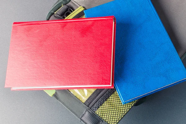 Красно-синяя книга лежит на сумке для ноутбука — стоковое фото