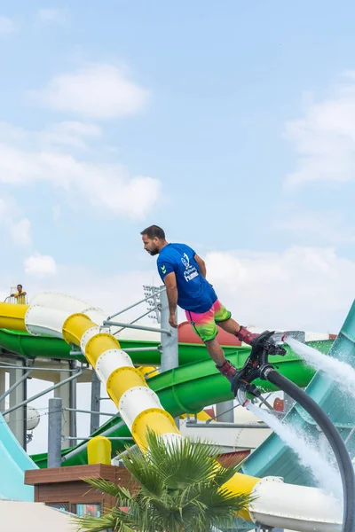 Lado, TURQUIA - JUNHO 1, 2018: Bonito homem bronzeado está em flyboard e voa contra o céu azul com nuvens . — Fotografia de Stock