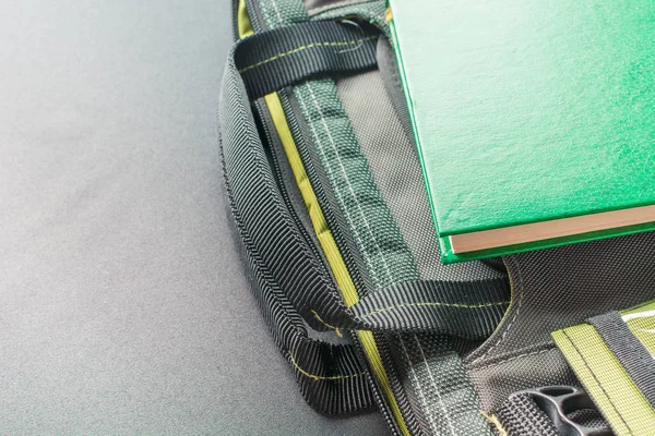Зеленая книга лежит на сумке для ноутбука — стоковое фото