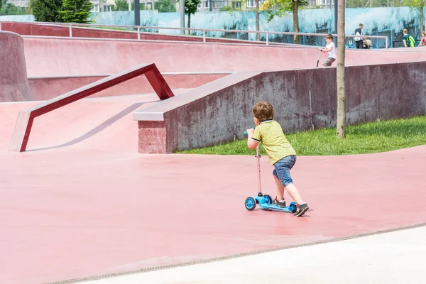 KRASNODAR, RUSSIA - 7 GIUGNO 2018: Piccolo bambino cavalca scooter per bambini su un campo sportivo speciale . — Foto Stock