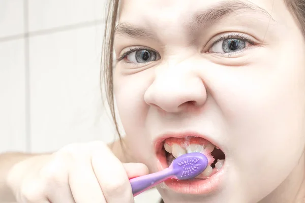 Красива дівчина чистить зуби у ванній неохоче — стокове фото