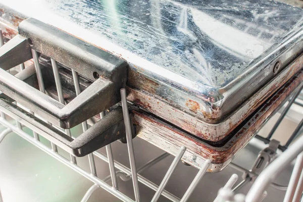Брудне вафельне залізо лежить на полиці посудомийної машини — стокове фото